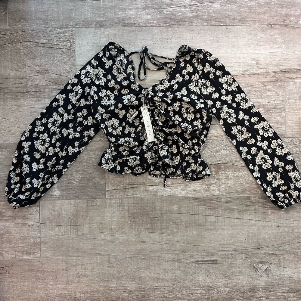 Beautiful black top with a floral pattern. Size medium and never worn.